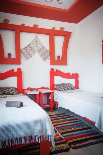 two beds in a room with red accents at Avto Spa in Khmelʼnytsʼkyy