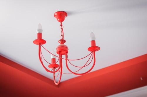 a red chandelier hanging from a white ceiling at Avto Spa in Khmelʼnytsʼkyy