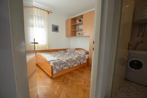 a small bedroom with a bed and a washing machine at Maja in Kornić