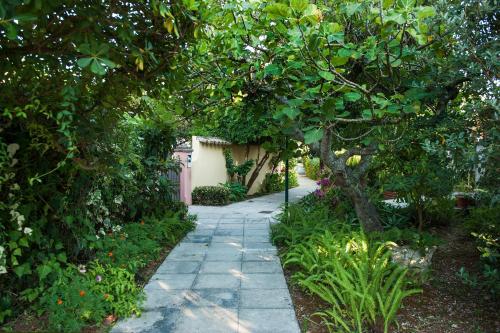 a garden path with a tree and a building at Spiti Prifti Apartments in Gouvia