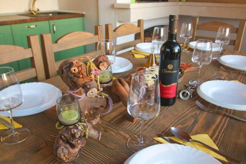 a wooden table with glasses and a bottle of wine at Villa Natasha in Makarska