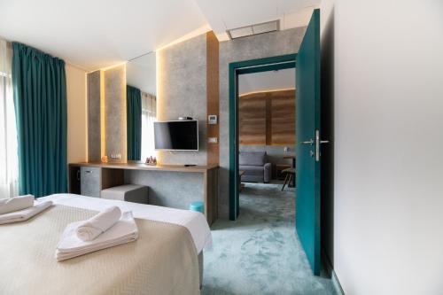 ベオグラードにあるHotel Notaのベッド2台とテレビが備わるホテルルームです。