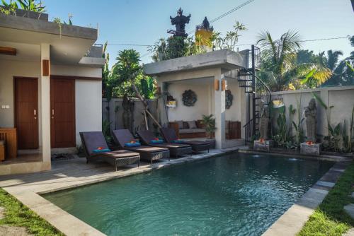 una piscina con sillas y una casa en Bisma Terrace Suite Ubud, en Ubud