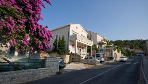 a street with pink flowers on the side of a building at Apartments Viva in Korčula