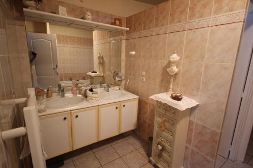 y baño con lavabo y espejo. en Bel Appartement climatisé de plain pied 80m de la mer grand séjour 2 chambres belle terrasse LXRM3, en Portiragnes