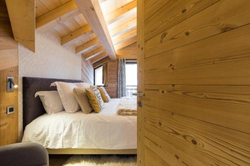 Schlafzimmer mit einem Bett mit weißer Bettwäsche und Kissen in der Unterkunft Chalet sur les monts Morzine in Montriond