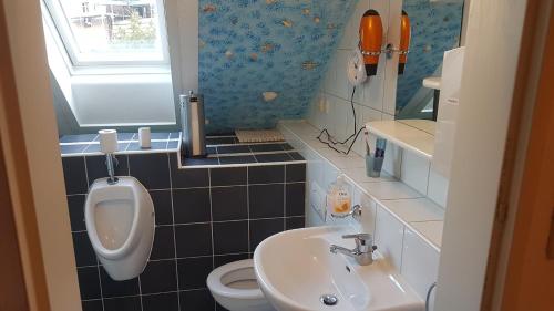 La salle de bains est pourvue de toilettes, d'un lavabo et d'un urinoir. dans l'établissement pension24 Kassel, à Cassel