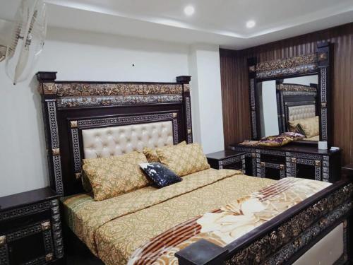 een slaapkamer met een bed en een grote spiegel bij HS Global Apartments in Rawalpindi