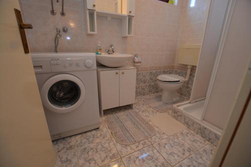 a bathroom with a washing machine and a sink at Maja in Kornić