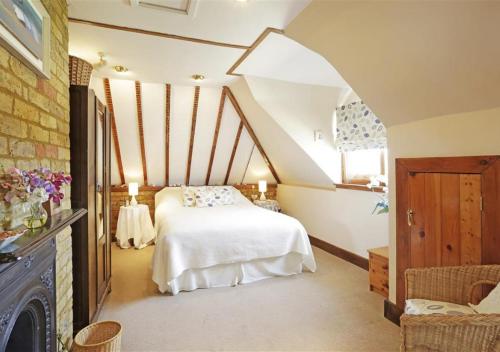 a bedroom with a white bed in a attic at Hollyhocks in Bawdsey
