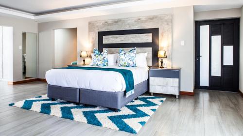 a bedroom with a large bed with blue pillows at Sagwadi Hotel in Hazyview