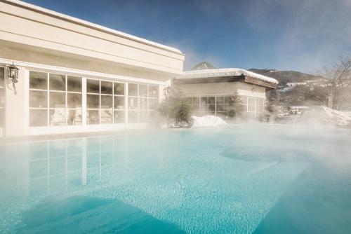 a large swimming pool in front of a building at Theresa Wellness-Genießer-Hotel in Zell am Ziller