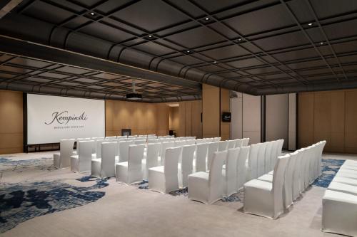 a conference room with white chairs and a screen at Kempinski Hotel Hangzhou in Hangzhou