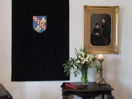 a vase of flowers on a table with a picture at Quinta do Campo in Nazaré