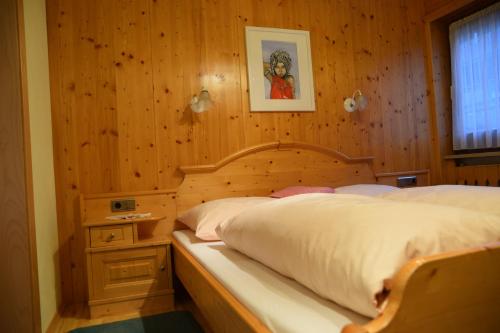 a bedroom with a bed with a wooden wall at Ferienwohnungen Annelies in Tux