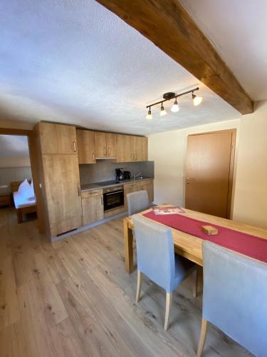 a kitchen and dining room with a wooden table and chairs at Haus Alpenrose in Waidring