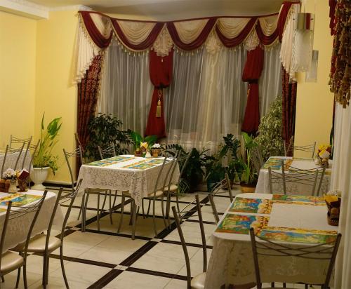 a dining room with tables and chairs and plants at ДОМ на ГРАЖДАНСКОЙ in Uglich