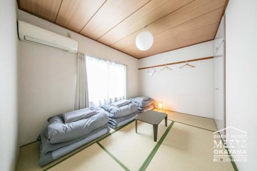 岡山市にあるGuest House MEETS Okayama 全室個室のホステルのベッド2台と窓が備わる客室です。