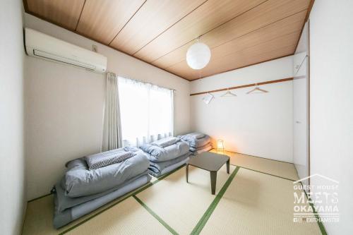 a room with two beds and a window at Guest House MEETS Okayama all private room hostel in Okayama