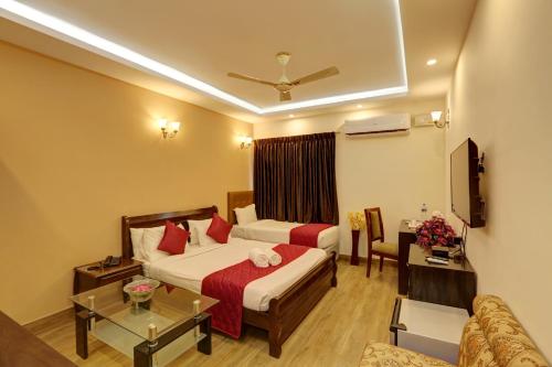 Hotel Windsor Castle Inn Brigade Rd في بانغالور: غرفة فندقية بسريرين واريكة