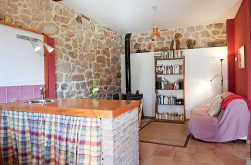 eine Küche mit einer Steinmauer und einer Theke mit einer Spüle in der Unterkunft Sendero del Agua in San Vicente del Monte