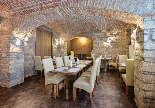 a dining room with a table and chairs and a brick wall at Hotel Prague Star in Prague