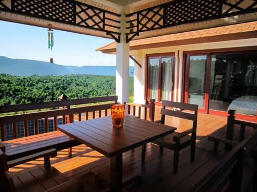 a wooden table on the deck of a house at Sabaidee Valley in Ban Gnik