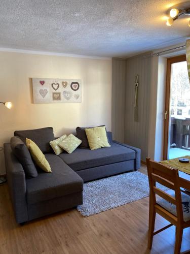 a living room with a couch and a table at Haus Alpenrose in Waidring