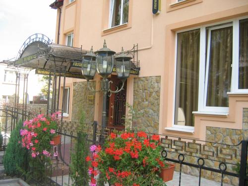 a house with flowers in front of a fence at Готель Преміум in Lviv
