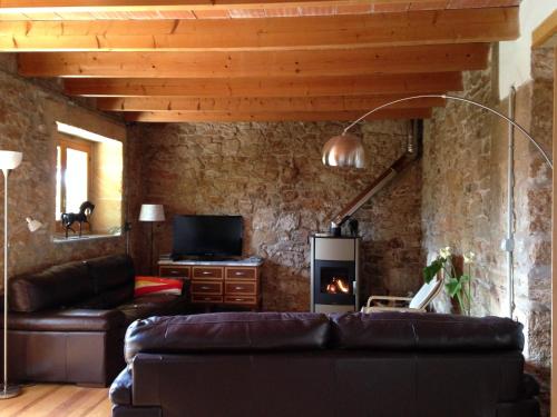 sala de estar con sofá de cuero y chimenea en Lujosa casa mallorquina restaurada, en Ses Salines