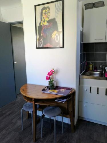 une petite cuisine avec une table et des chaises en bois dans l'établissement Le Moussaillon - F2 à 20 m de la plage, à Palavas-les-Flots