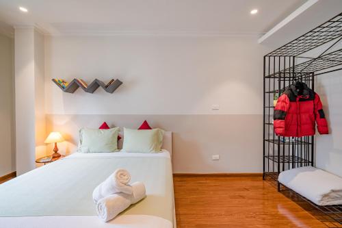 a bedroom with a bed and a rack of clothes at WECOZY HANOI - Railway Side, The Old Quarter in Hanoi