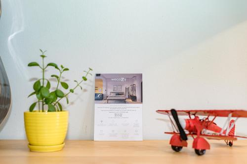 a toy plane sitting on a table next to a plant at WECOZY HANOI - Railway Side, The Old Quarter in Hanoi