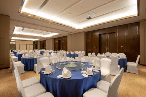 a conference room with a blue table and white chairs at Junluxe Hotel Guangzhou Science City-Free Shuttle Bus Service to Guangzhou Canton Fair in Guangzhou