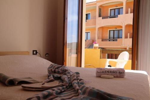 - un lit avec une serviette et une paire de sandales dans l'établissement SARDINIA RE - Casa La Spiga, à Castelsardo