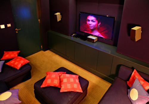 a room with two couches and a flat screen tv at Aria Hotel Prague in Prague