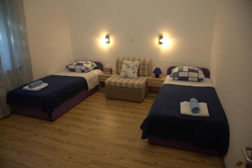 RavaにあるApartments Vila Milevaのベッド2台とソファが備わる客室です。