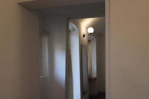 a hallway with a mirror and a light on a wall at Bed&Braja in Vische