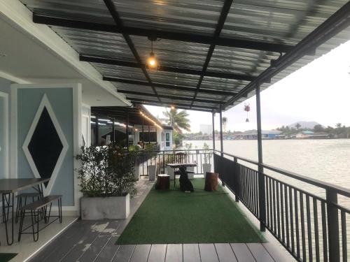 une terrasse avec une table et un tapis vert dans l'établissement Chaiyai River Front Hotel, à Sichon