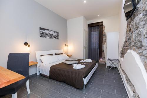 Un dormitorio con una cama, un escritorio y una mesa. en Passi di Mare Rooms, en Giardini Naxos