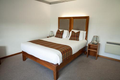 a bedroom with a large bed with white sheets and pillows at Berwick Manor Hotel in Rainham