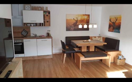 een woonkamer met een tafel en een keuken bij Ferienwohnungen Michel in Winterberg