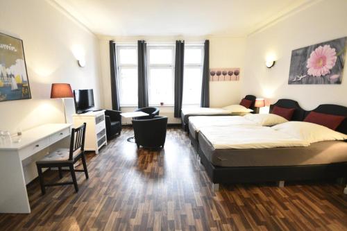 a hotel room with two beds and a desk at Pension am Schloss in Schwerin