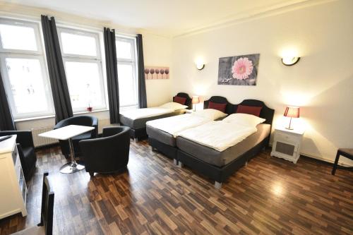 a bedroom with a bed and a table and chairs at Pension am Schloss in Schwerin