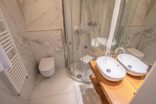 La salle de bains est pourvue d'une douche, d'un lavabo et de toilettes. dans l'établissement Hotel Resort Veronza, à Cavalese
