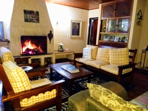 坎普斯杜若爾當的住宿－Pousada Casa D'Antonia，带沙发和壁炉的客厅