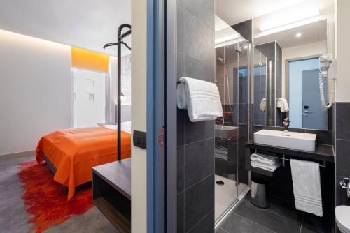 a bathroom with a bed and a sink and a mirror at Campanile Vienna South in Vienna