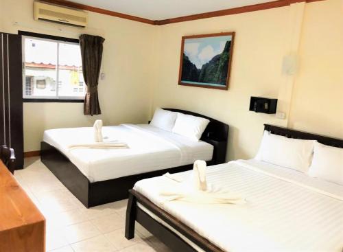 a hotel room with two beds and a window at Golden Bee PhiPhi in Phi Phi Don
