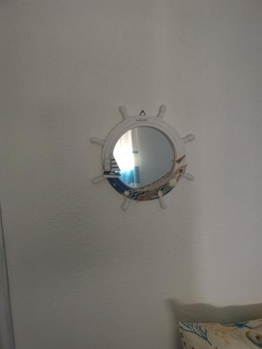 a mirror is hanging on a white wall at 4 stagioni in Villasimius