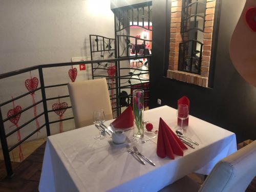 a white table with red napkins and silverware at Sosnowe Zacisze in Białystok